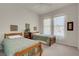 A naturally illuminated bedroom featuring two beds, a bookshelf, and tasteful wall decor at 11032 Mission Lakes Ave, Las Vegas, NV 89134