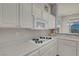 Kitchen features white cabinetry, countertops, and a gas cooktop at 11032 Mission Lakes Ave, Las Vegas, NV 89134
