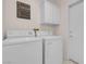 Clean laundry room features a washer, dryer, cabinet, and access to the backyard at 11032 Mission Lakes Ave, Las Vegas, NV 89134