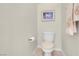 Neutral half-bathroom features artwork, a towel rack, and a toilet at 11032 Mission Lakes Ave, Las Vegas, NV 89134