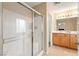 Well-lit bathroom featuring a glass-enclosed shower and double sink vanity at 11135 Abbeyfield Rose Dr, Henderson, NV 89052