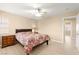 Bedroom featuring a floral-patterned comforter, a ceiling fan, and an attached ensuite at 11135 Abbeyfield Rose Dr, Henderson, NV 89052