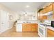 Bright kitchen featuring wooden cabinets, a white countertop and appliances, and tile flooring at 11135 Abbeyfield Rose Dr, Henderson, NV 89052