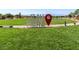 Wide shot of the community green space with the prominent community sign 