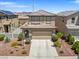 Frontal home exterior featuring lush landscape, two-car garage, and driveway at 1124 Aspen Cliff Dr, Henderson, NV 89011