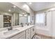 Bathroom featuring double sinks, white cabinetry, a soaking tub, and wooden-look flooring at 1267 Dorado Sea Ct, Henderson, NV 89052
