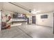 Spacious garage with epoxy floor, wall-mounted tool storage, and a mounted television at 1267 Dorado Sea Ct, Henderson, NV 89052