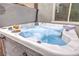 Close-up of a luxurious hot tub with drinks, towels, and jets for ultimate relaxation at 1267 Dorado Sea Ct, Henderson, NV 89052