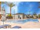 Community pool with lounge chairs and palm trees on a sunny day at 1267 Dorado Sea Ct, Henderson, NV 89052
