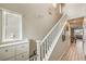 Bright stairway featuring white railing, neutral walls with decorative elements, and wood flooring at 1267 Dorado Sea Ct, Henderson, NV 89052