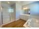 Bathroom featuring glass shower, vanity, soaking tub, and wood-look floors at 138 Short Grass Ave, Las Vegas, NV 89148