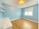 This bedroom features light blue walls, a window, and wood flooring at 138 Short Grass Ave, Las Vegas, NV 89148