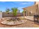 A home's backyard featuring a covered patio, an outdoor grill, and gravel landscaping at 1813 Arch Stone Ave, North Las Vegas, NV 89031