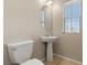 A half bathroom features a pedestal sink, tile flooring and a comfort height toilet at 1813 Arch Stone Ave, North Las Vegas, NV 89031