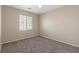 Simple bedroom features carpet, neutral paint, a ceiling fan, and a bright window at 1813 Arch Stone Ave, North Las Vegas, NV 89031