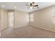 Neutral bedroom featuring a ceiling fan, plush carpeting, and natural light from the window at 1813 Arch Stone Ave, North Las Vegas, NV 89031