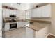 Well-lit kitchen with white cabinets, granite countertops, stainless steel appliances, and a tiled floor at 1813 Arch Stone Ave, North Las Vegas, NV 89031