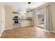 An open concept kitchen features white cabinets and granite countertops and tile flooring at 1813 Arch Stone Ave, North Las Vegas, NV 89031