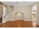 Spacious living area features hardwood floors, staircase access, and an arched display nook with neutral wall paint at 1813 Arch Stone Ave, North Las Vegas, NV 89031