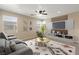 Comfortable living room with modern furniture, TV, ceiling fan, and abundant natural light at 1813 Arch Stone Ave, North Las Vegas, NV 89031