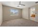 Spacious main bedroom featuring a ceiling fan, neutral walls, and a window with bright natural light at 1813 Arch Stone Ave, North Las Vegas, NV 89031