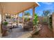 Relaxing covered patio with comfortable seating, stone landscaping, and sunny backyard at 1813 Arch Stone Ave, North Las Vegas, NV 89031