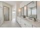 Bright bathroom with dual sinks, quartz countertop, decorative mirrors, and modern fixtures at 1964 Oliver Springs St, Henderson, NV 89052