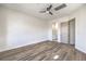 Bright bedroom with wood-look flooring, ceiling fan, and a door to the ensuite bathroom at 1964 Oliver Springs St, Henderson, NV 89052