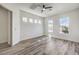 Bright bedroom with wood-look flooring, ceiling fan, and a wall of windows at 1964 Oliver Springs St, Henderson, NV 89052