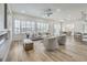 Bright open-concept living area with wood-look tile, modern furnishings, and abundant natural light from large windows at 1964 Oliver Springs St, Henderson, NV 89052