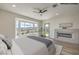 Bright main bedroom with fireplace, ceiling fan, and a large picture window showcasing scenic views at 1964 Oliver Springs St, Henderson, NV 89052