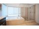 Bright bathroom featuring a soaking tub, separate glass shower, and neutral tile, creating a relaxing retreat at 204 N Ring Dove Dr, Las Vegas, NV 89144