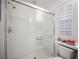 Bright bathroom featuring a glass-enclosed shower with white tiling and a window with white shutters at 204 N Ring Dove Dr, Las Vegas, NV 89144