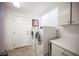 Neat laundry room includes a side by side washer and dryer and cabinets for storage at 204 N Ring Dove Dr, Las Vegas, NV 89144