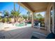 Covered outdoor patio with seating, a view of the pool area, and serene landscaping at 204 N Ring Dove Dr, Las Vegas, NV 89144