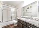 Bathroom featuring a shower-tub combo, updated granite counters, and wood flooring at 2261 Tall Pine Dr, Las Vegas, NV 89108