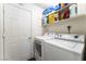 Functional laundry room with shelving for storage and a standard washer and dryer at 2261 Tall Pine Dr, Las Vegas, NV 89108