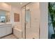 Clean, bright bathroom featuring a tub shower combo with glass surround, large mirror, and modern vanity at 240 White Crest Peak Ave, Henderson, NV 89015