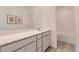 White bathroom features a long vanity with double sinks, a large mirror, and a tub shower combo at 240 White Crest Peak Ave, Henderson, NV 89015