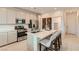 Bright kitchen features stainless appliances, white cabinets, quartz counters and a central island with seating at 240 White Crest Peak Ave, Henderson, NV 89015