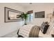 Cozy bedroom showcases a decorative mirror, plant, throw pillows, and natural light from the window at 242 White Crest Peak Ave, Henderson, NV 89015