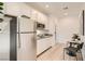 Well-lit kitchen featuring stainless steel appliances, white cabinetry, and a cozy breakfast nook with seating at 242 White Crest Peak Ave, Henderson, NV 89015