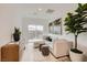 Bright living room with a comfortable sectional sofa, stylish decor, and sliding glass doors to the patio at 242 White Crest Peak Ave, Henderson, NV 89015