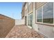Charming outdoor patio area with brick pavers, privacy wall, and a sliding glass door entrance at 242 White Crest Peak Ave, Henderson, NV 89015