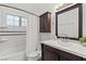 Well-lit bathroom features dark wood vanity, framed mirror, tub, and decorative wall tiles at 2513 Aberdeen Ln, Henderson, NV 89014