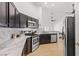 Modern kitchen with stainless steel appliances, dark cabinets, and marble countertops at 2513 Aberdeen Ln, Henderson, NV 89014