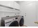 Updated laundry room with front loading machines and ample storage above the appliances at 2513 Aberdeen Ln, Henderson, NV 89014
