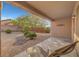 Charming backyard with patio, lounge chair, desert landscaping, and privacy wall at 2613 Velodrome Ct, Henderson, NV 89044