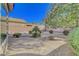 Low maintenance backyard with mature trees and gravel and foliage for an easy-care desert landscape at 2613 Velodrome Ct, Henderson, NV 89044