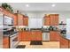 Well-lit kitchen showcases stainless steel appliances, wooden cabinets, and tile flooring at 2613 Velodrome Ct, Henderson, NV 89044